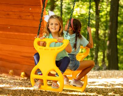 Two Girls Swinging on Two Seater Glider Swing on Playset